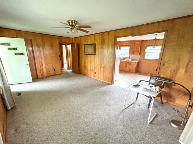 72 Allen Ln, Huntingdon, TN 38344 - unfurnished living room featuring wood walls, ceiling fan, light carpet, and baseboards