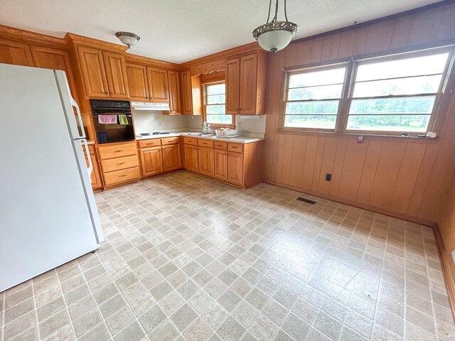 72 Allen Ln, Huntingdon, TN 38344 - kitchen with white appliances, light countertops, under cabinet range hood, a sink, and brown cabinets
