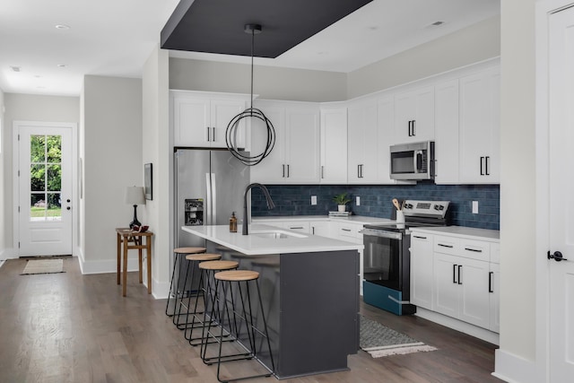 1816A Ashton Ave, Nashville, TN 37218 - kitchen with stainless steel appliances, a sink, dark wood-style floors, an island with sink, and backsplash