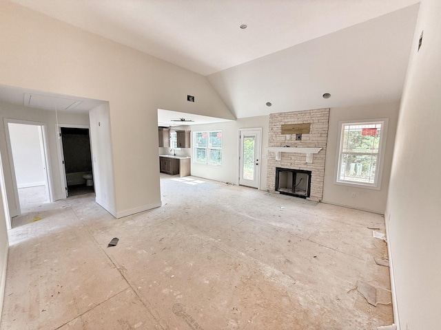 209 Griffey Ests, Clarksville, TN 37042 - unfurnished living room with plenty of natural light, attic access, a stone fireplace, and lofted ceiling