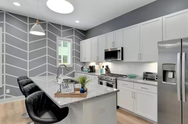 1144 Harmony Way, Nashville, TN 37207 - kitchen featuring appliances with stainless steel finishes, a sink, light stone counters, backsplash, and white cabinets