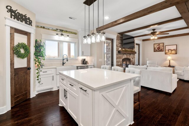 2824 Robert Truelove Rd, Columbia, TN 38401 - kitchen featuring a sink, a stone fireplace, dark wood-style flooring, light countertops, and a kitchen bar