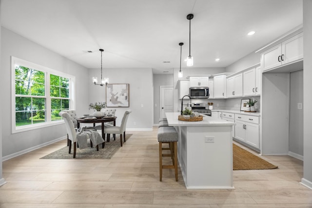 264 Kildeer Dr, Clarksville, TN 37040 - kitchen featuring appliances with stainless steel finishes, light countertops, a chandelier, baseboards, and light wood finished floors