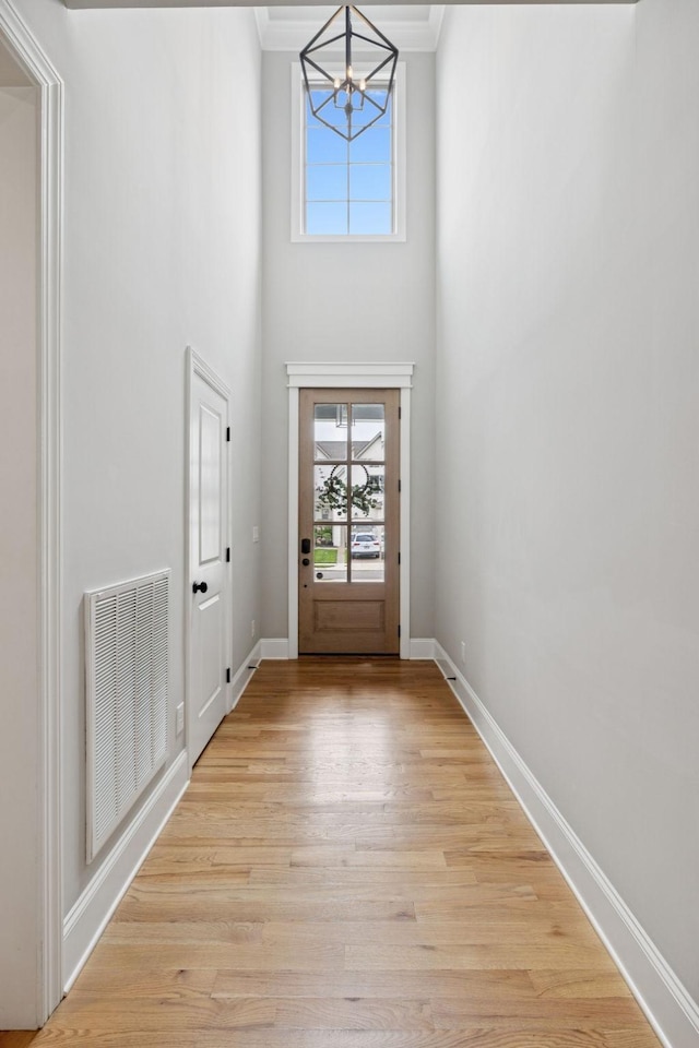 1712 Sorrell Park Dr, Spring Hill, TN 37174 - entryway featuring a chandelier, plenty of natural light, light wood-style flooring, crown molding, and a towering ceiling