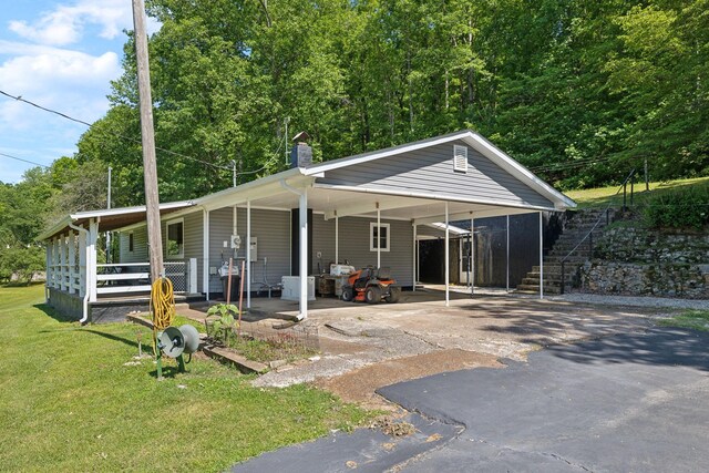 1540 Centerville Hwy, Hohenwald, TN 38462 - view of front of house featuring driveway, a front lawn, a chimney, an attached carport, and a porch