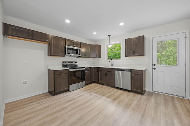 174 Oak St, Clarksville, TN 37042 - kitchen with stainless steel appliances, dark brown cabinets, light wood-style floors, light countertops, and recessed lighting
