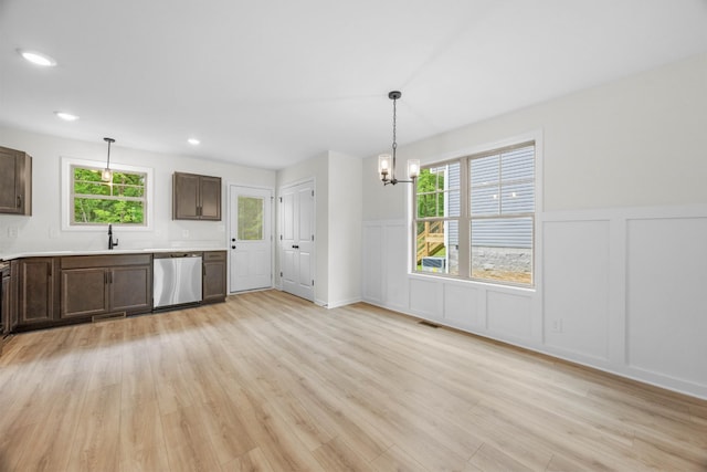 174 Oak St, Clarksville, TN 37042 - kitchen with stainless steel dishwasher, a chandelier, a decorative wall, light wood finished floors, and dark brown cabinetry