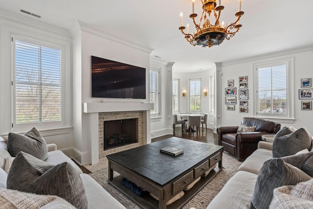 100 Church St, Franklin, TN 37064 - living area with a chandelier, crown molding, a fireplace, baseboards, and decorative columns