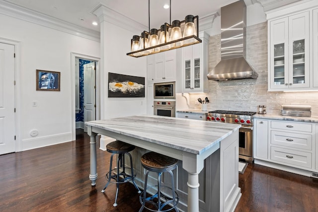 100 Church St, Franklin, TN 37064 - kitchen featuring appliances with stainless steel finishes, wall chimney range hood, ornamental molding, light stone counters, and white cabinets