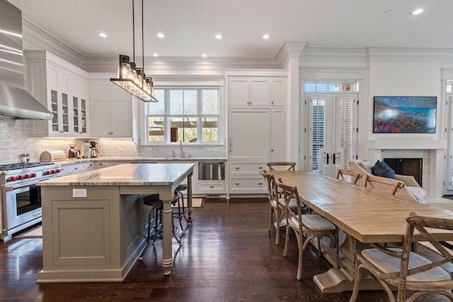 100 Church St, Franklin, TN 37064 - kitchen with premium range, ornamental molding, a center island, healthy amount of natural light, and wall chimney exhaust hood