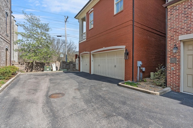 100 Church St, Franklin, TN 37064 - view of property exterior with a garage, asphalt driveway, and brick siding