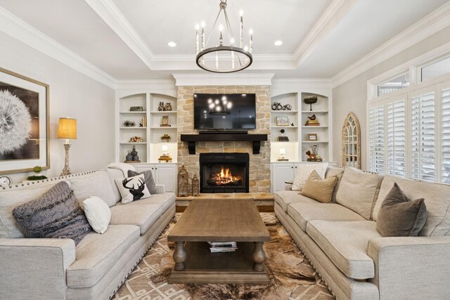 2433 Durham Manor Dr, Franklin, TN 37064 - living area with a fireplace, ornamental molding, a chandelier, a raised ceiling, and built in shelves