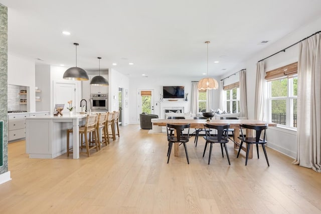 4042 Flowing Creek Dr, Franklin, TN 37064 - dining space with light wood-style floors, a fireplace, recessed lighting, and baseboards