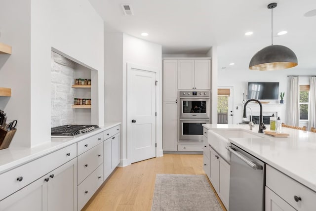 4042 Flowing Creek Dr, Franklin, TN 37064 - kitchen featuring appliances with stainless steel finishes, a sink, light wood finished floors, light countertops, and white cabinets