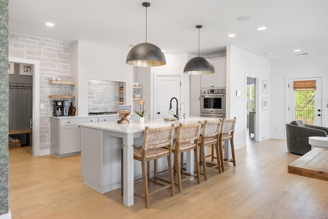 4042 Flowing Creek Dr, Franklin, TN 37064 - kitchen featuring oven, light wood finished floors, light countertops, a breakfast bar, and recessed lighting