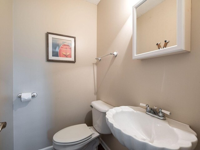 2999 Cages Bend Rd, Gallatin, TN 37066 - half bathroom featuring a sink, toilet, and baseboards