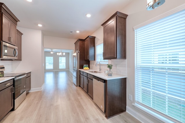3254 Tasker Dr, Antioch, TN 37013 - kitchen featuring appliances with stainless steel finishes, a sink, dark brown cabinets, light wood-type flooring, and tasteful backsplash