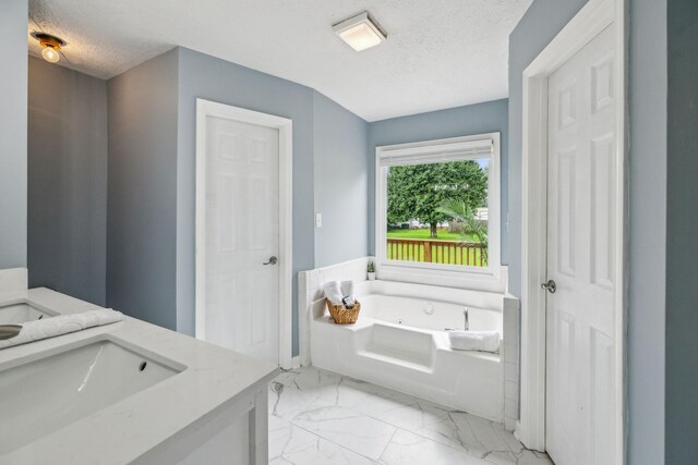 124 Mabry Dr, Murfreesboro, TN 37127 - bathroom featuring a garden tub, vanity, a textured ceiling, and marble look tile flooring