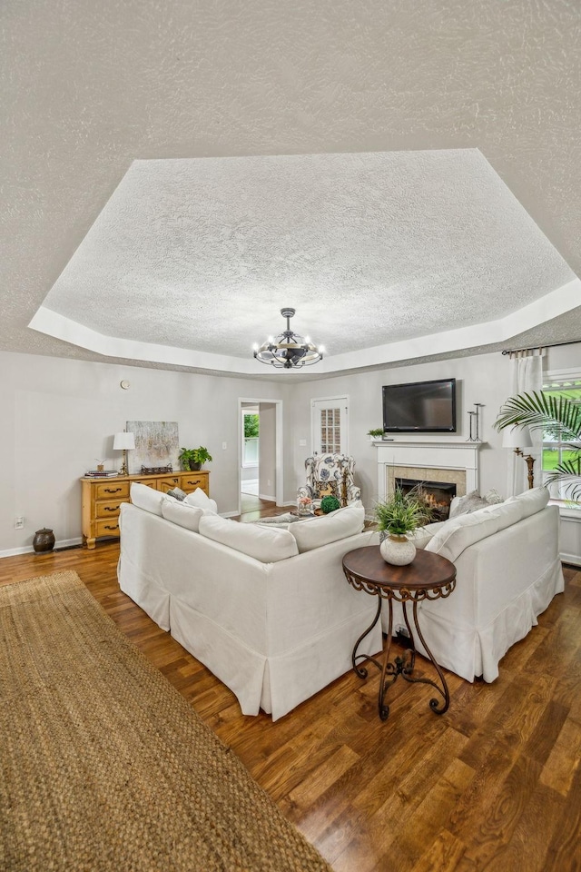 124 Mabry Dr, Murfreesboro, TN 37127 - living area featuring a textured ceiling, a chandelier, wood finished floors, a tiled fireplace, and a tray ceiling