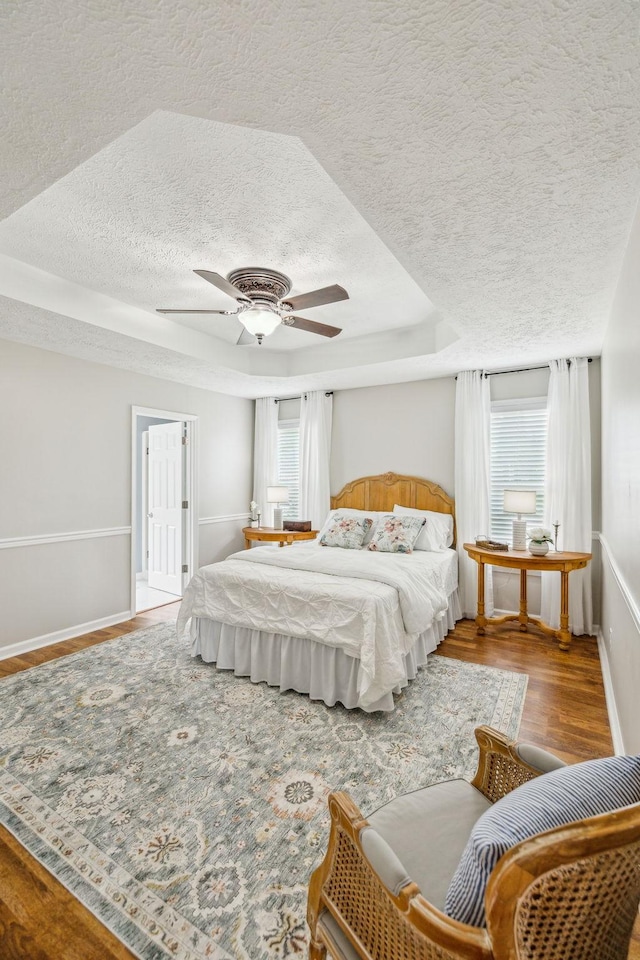 124 Mabry Dr, Murfreesboro, TN 37127 - bedroom featuring a textured ceiling, wood finished floors, a raised ceiling, baseboards, and ceiling fan