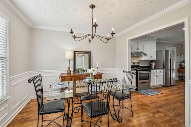 124 Mabry Dr, Murfreesboro, TN 37127 - dining space with a textured ceiling, a chandelier, wood finished floors, wainscoting, and crown molding