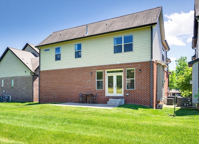 2734 Lakeland Dr, Nashville, TN 37214 - back of property with french doors, entry steps, a lawn, central air condition unit, and brick siding