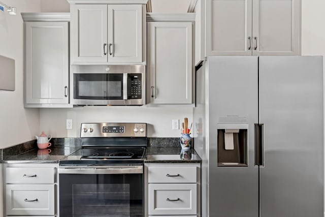 114 Eno Rd, Dickson, TN 37055 - kitchen featuring appliances with stainless steel finishes, dark stone countertops, and white cabinetry