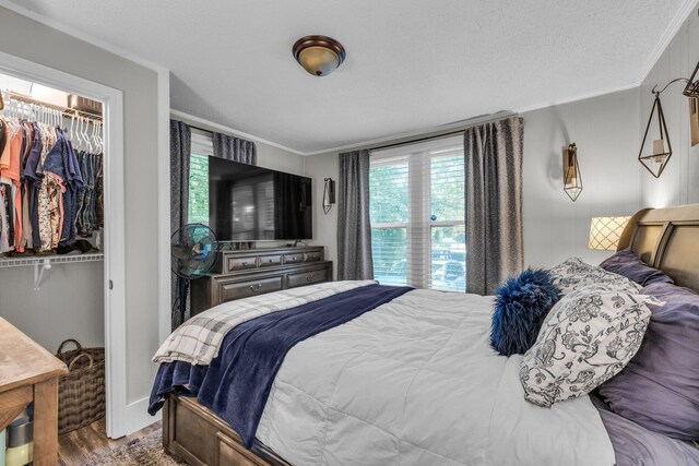 2106 Tunnel Blvd, Chattanooga, TN 37406 - bedroom with ornamental molding, wood finished floors, a walk in closet, a closet, and a textured ceiling