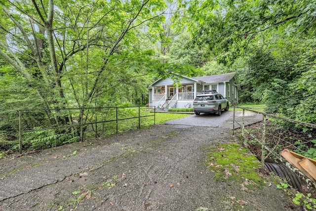 2106 Tunnel Blvd, Chattanooga, TN 37406 - view of front facade with a porch, asphalt driveway, and a wooded view