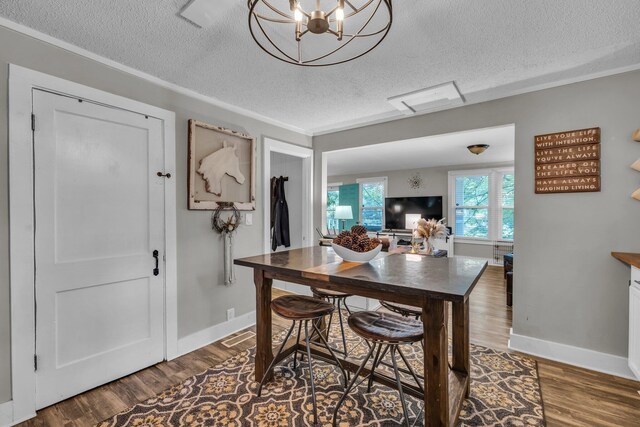 2106 Tunnel Blvd, Chattanooga, TN 37406 - dining area featuring a textured ceiling, wood finished floors, baseboards, a chandelier, and ornamental molding