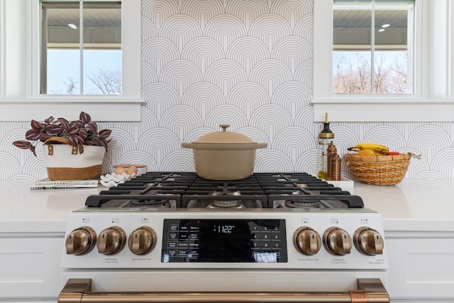 1222 Rock Church Rd, Dickson, TN 37055 - kitchen view of stainless steel range with gas cooktop, tasteful backsplash, light countertops, and white cabinetry