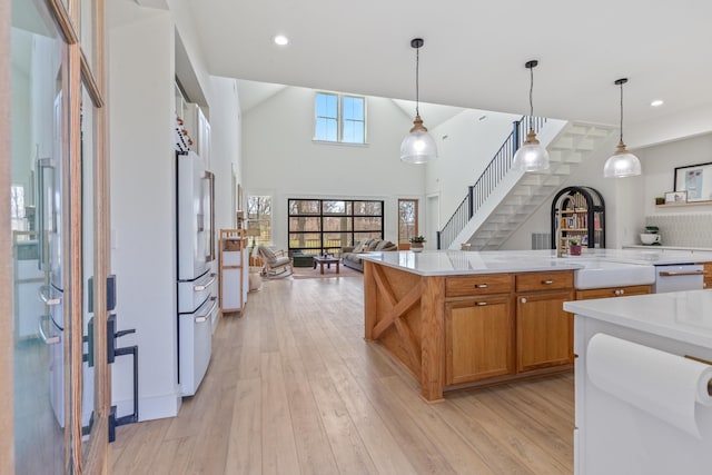 1222 Rock Church Rd, Dickson, TN 37055 - kitchen featuring light countertops, brown cabinets, open floor plan, white refrigerator, and a sink