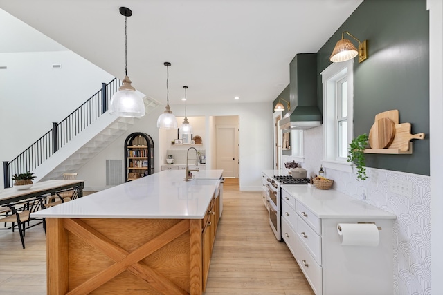 1222 Rock Church Rd, Dickson, TN 37055 - kitchen featuring wall chimney range hood, range with two ovens, a sink, light wood-type flooring, and recessed lighting