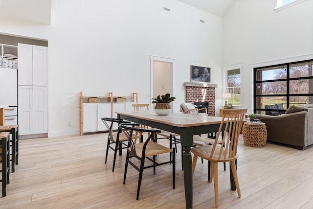 1222 Rock Church Rd, Dickson, TN 37055 - dining space with high vaulted ceiling, light wood-style floors, plenty of natural light, a fireplace, and baseboards