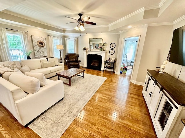 593 Imperial Dr, Sparta, TN 38583 - living room with light wood finished floors, a ceiling fan, a tray ceiling, a fireplace with flush hearth, and ornamental molding
