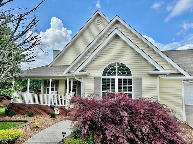 593 Imperial Dr, Sparta, TN 38583 - view of front of home with covered porch, a shingled roof, a chimney, and an attached garage