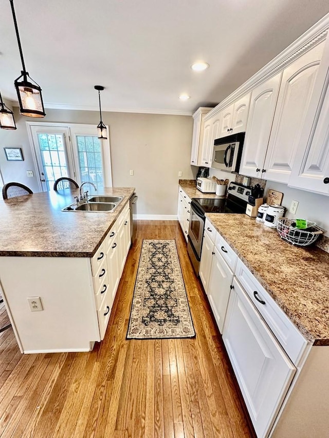 593 Imperial Dr, Sparta, TN 38583 - kitchen featuring appliances with stainless steel finishes, a sink, wood finished floors, a center island with sink, and white cabinets
