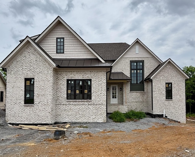 306 Oaks Xing, Lebanon, TN 37087 - view of front facade with a standing seam roof, brick siding, metal roof, and roof with shingles