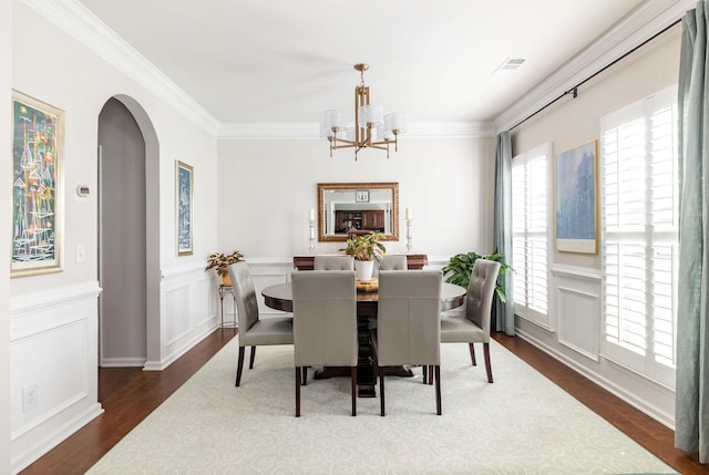 6050 Huntmere Ave, Franklin, TN 37064 - dining room featuring a chandelier, arched walkways, dark wood-style flooring, crown molding, and a wainscoted wall