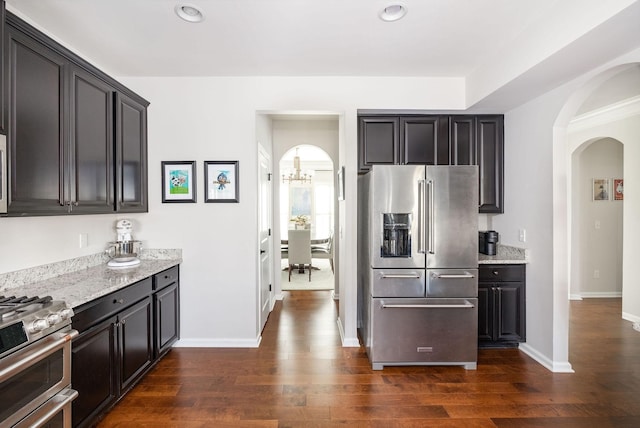 6050 Huntmere Ave, Franklin, TN 37064 - kitchen with stainless steel appliances, arched walkways, dark wood-type flooring, light stone countertops, and recessed lighting