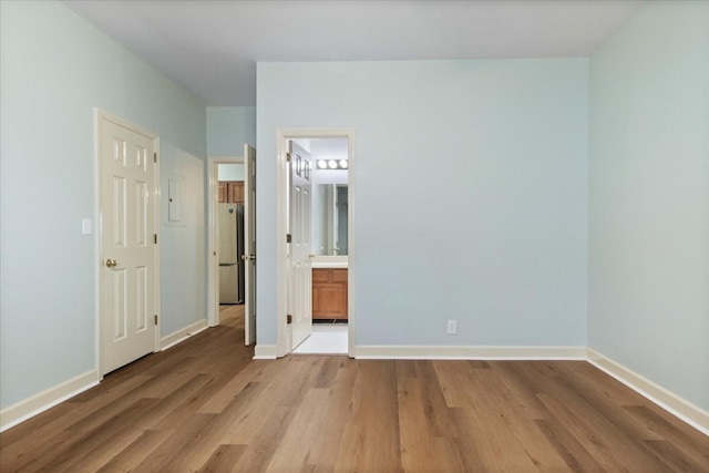 2101 Benton Hall Ct, Columbia, TN 38401 - unfurnished bedroom featuring light wood finished floors, baseboards, freestanding refrigerator, and connected bathroom