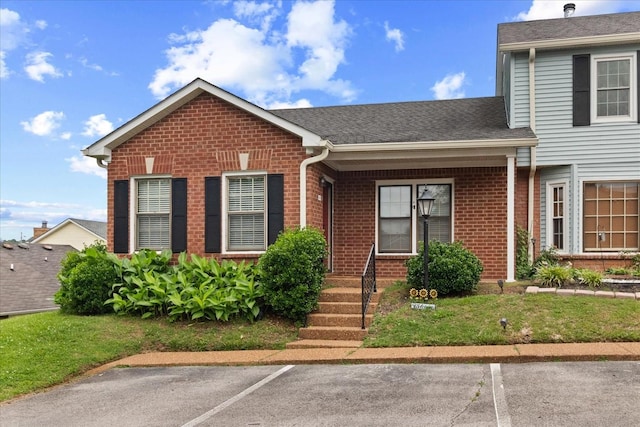 2101 Benton Hall Ct, Columbia, TN 38401 - view of front of house featuring brick siding, uncovered parking, a shingled roof, and a porch