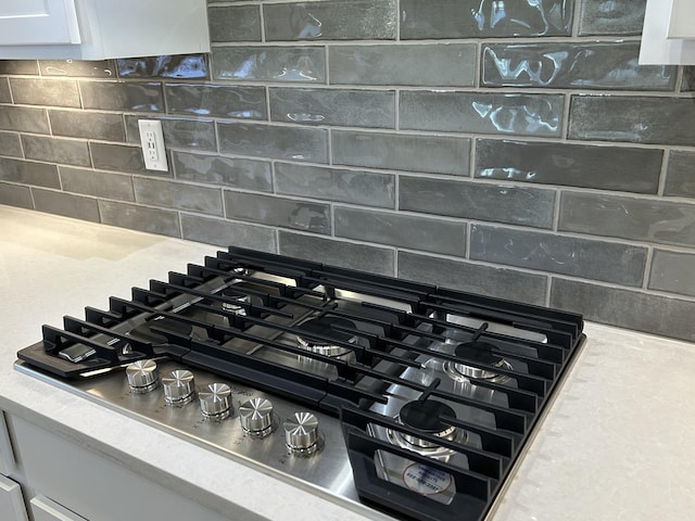 6705 Major Hutchings Dr, Hermitage, TN 37076 - kitchen view of tasteful backsplash, stainless steel gas cooktop, light countertops, and white cabinetry