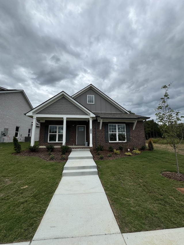 6705 Major Hutchings Dr, Hermitage, TN 37076 - craftsman-style home with covered porch, brick siding, a front yard, and board and batten siding