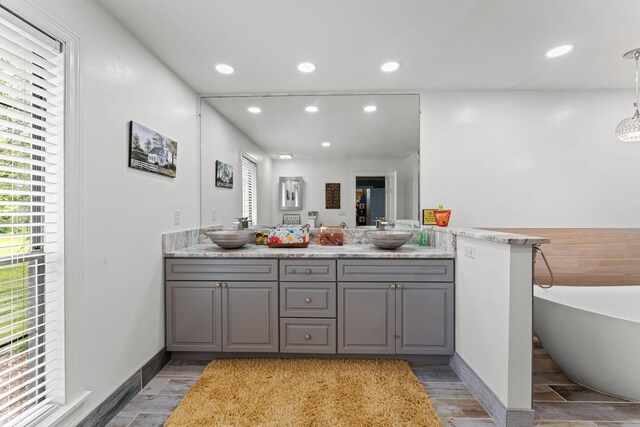 1313 Stayton Rd, Cumberland Furnace, TN 37051 - bathroom with double vanity, a soaking tub, recessed lighting, wood finished floors, and baseboards