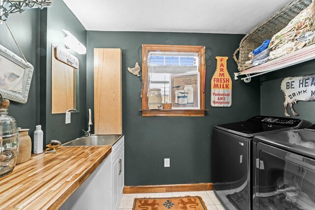1313 Stayton Rd, Cumberland Furnace, TN 37051 - laundry area featuring cabinet space, separate washer and dryer, light tile patterned flooring, and baseboards