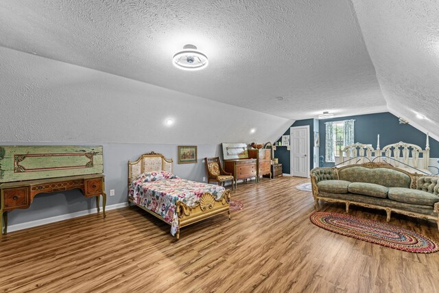 1313 Stayton Rd, Cumberland Furnace, TN 37051 - bedroom featuring a textured ceiling, wood finished floors, lofted ceiling, and baseboards