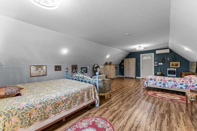 1313 Stayton Rd, Cumberland Furnace, TN 37051 - bedroom with a wall mounted air conditioner, wood finished floors, a textured ceiling, lofted ceiling, and baseboards