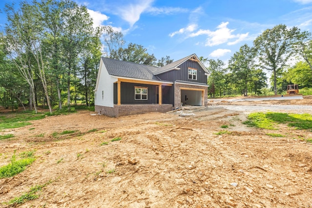1586 Ryes Chapel Rd, Southside, TN 37171 - view of front facade with an attached garage, dirt driveway, and covered porch