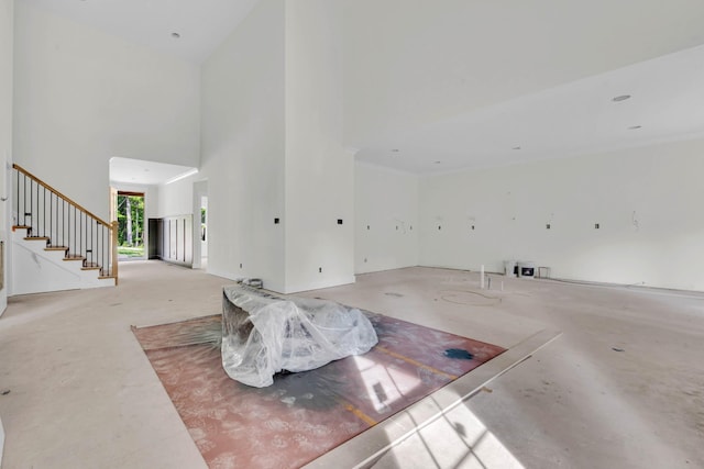 1586 Ryes Chapel Rd, Southside, TN 37171 - unfurnished living room with a towering ceiling, stairway, and concrete floors
